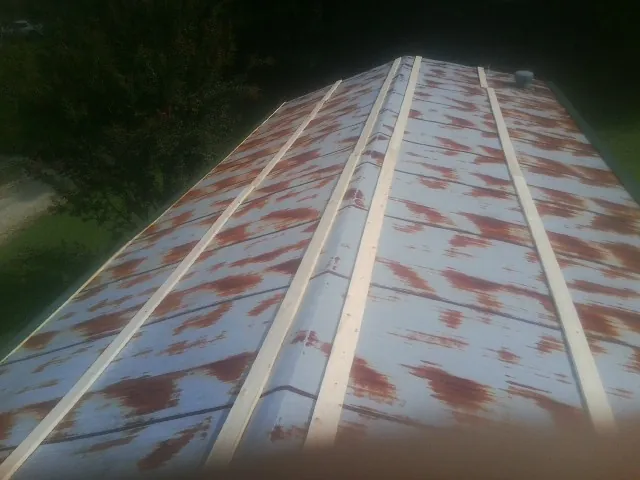 Rusted metal roof panels with new wood purlins before replacement — Storm Damage Roof Repair in Metter by Roofing Brothers