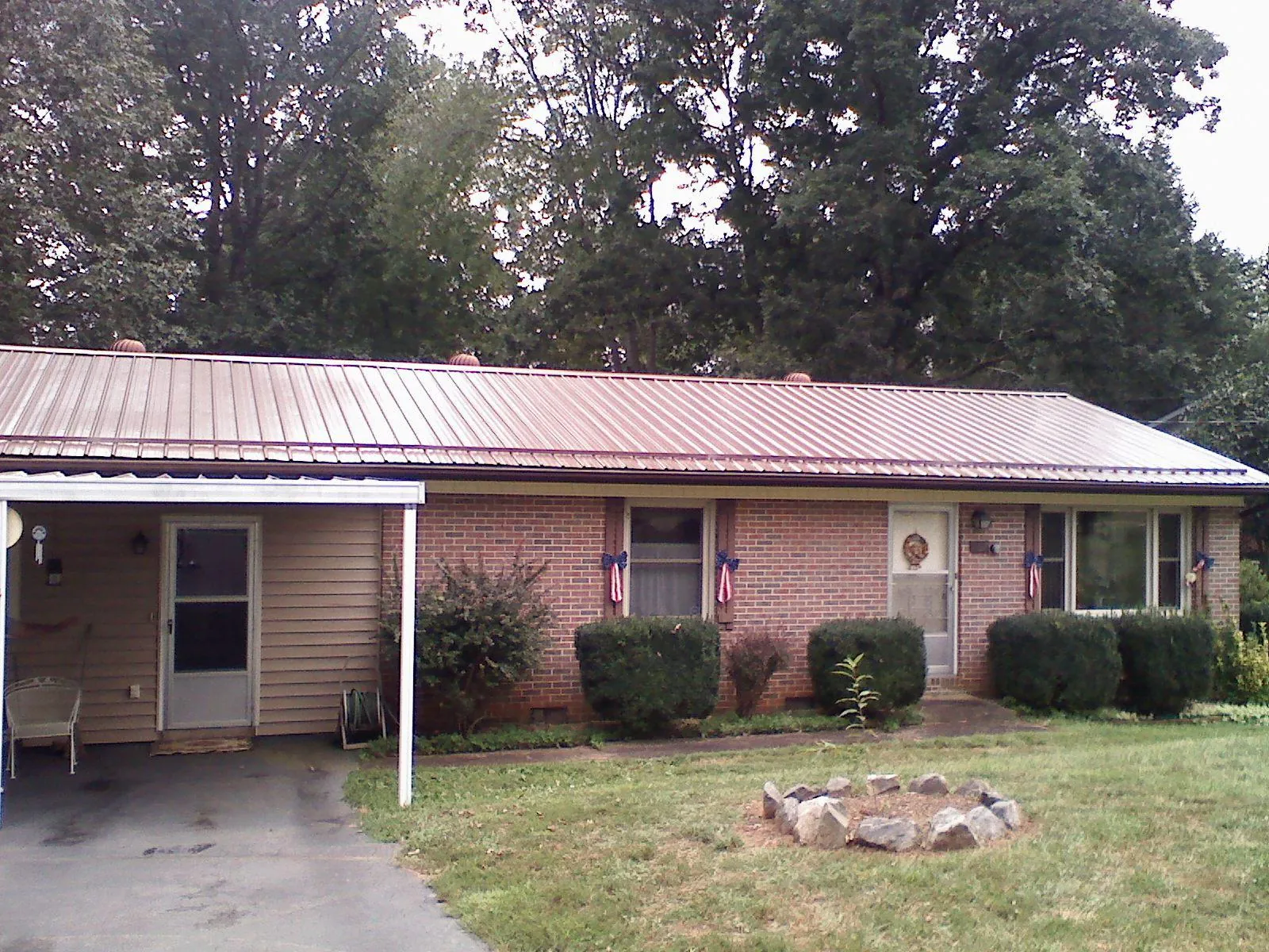 Bronze metal roof and carport on a brick ranch home — Roof Repair work by our crew in Metter